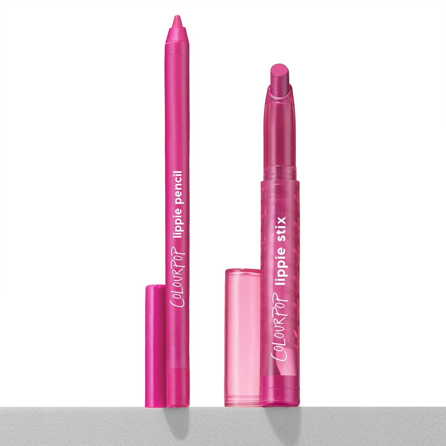 Heart Lips ColourPop Lippie Stix + Pencil Set showing the creamy fuchsia lipstick and matching liner uncapped, upright on a white surface with translucent pink caps nearby and ColourPop branding visible.