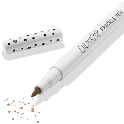 ColourPop Freckle Pen in Soft Brown uncapped, felt-tip applying scattered soft brown freckle dots, with polka-dot white cap beside it on a clean white background; long-wearing, buildable faux freckles makeup.