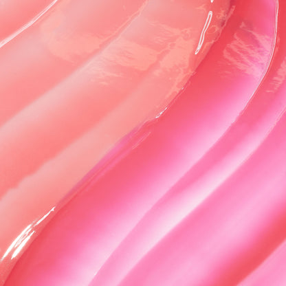 Glossy pink lip oil swatches flowing in wavy stripes, showcasing It’s Giving Juicy, the ColourPop So Juicy Lip Oil Set, with high-shine finish and gradient rosy shades on a smooth surface.