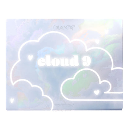 Cloud 9 ColourPop Shadow Palette sits closed, showing a holographic pastel sky design with white outlined clouds, tiny heart icons, and bold 'cloud 9' lettering on the lid, a rectangular pressed powder eyeshadow palette on a white backdrop.