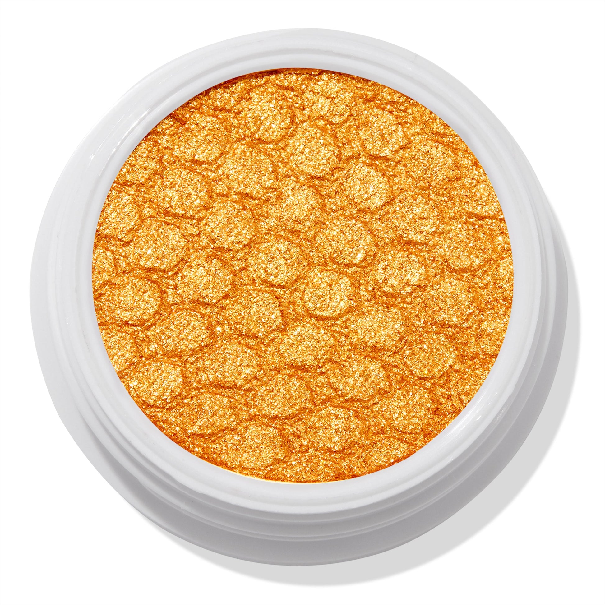 Montecito Super Shock Shadow by ColourPop shimmering in a bold metallic marigold-gold pan, embossed with a honeycomb texture, set in a round white pot against a clean white background.