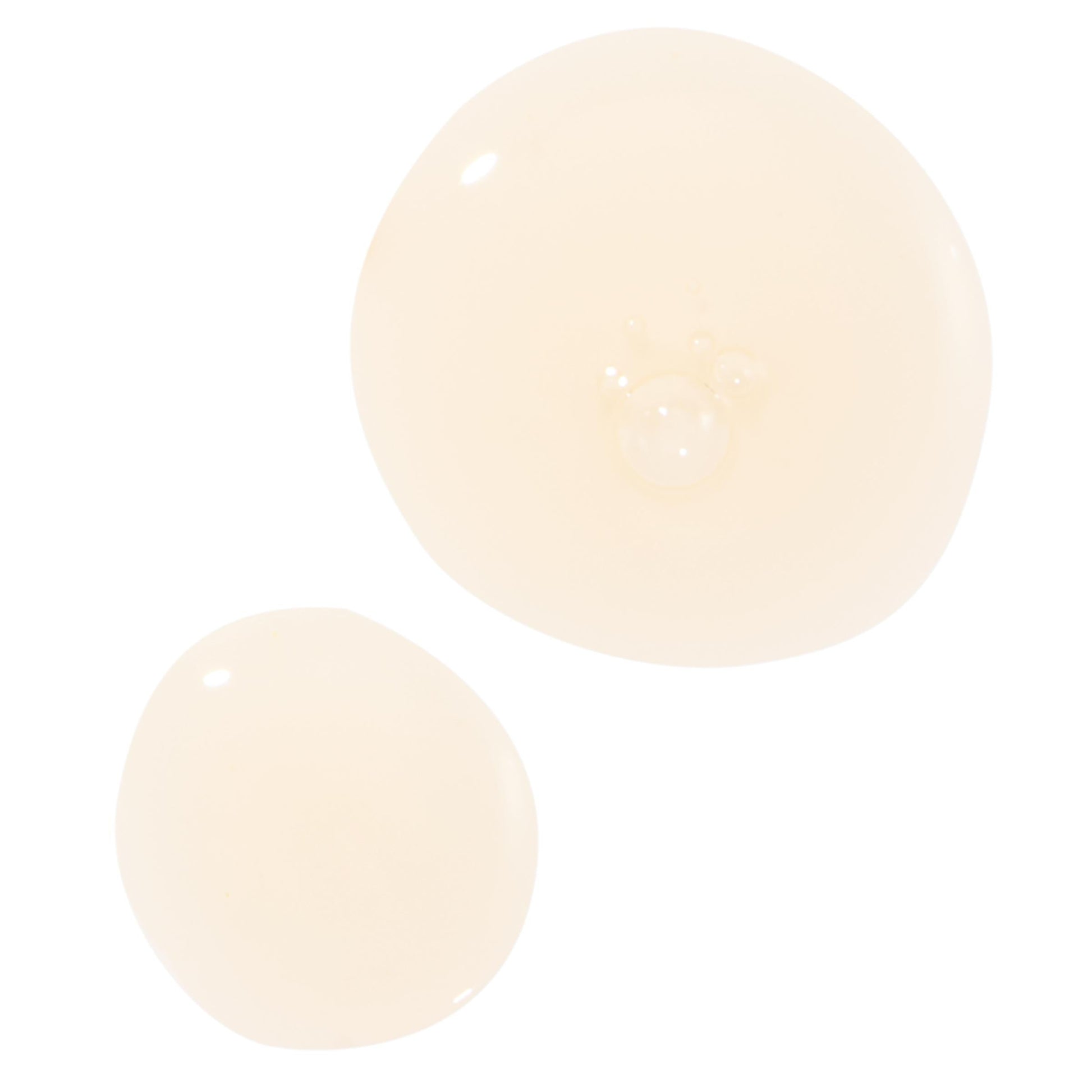 Turmeric Serum swatch forming two glossy, translucent drops with tiny bubbles on a clean white background, highlighting the lightweight texture and dewy finish of the ColourPop Face Serum.