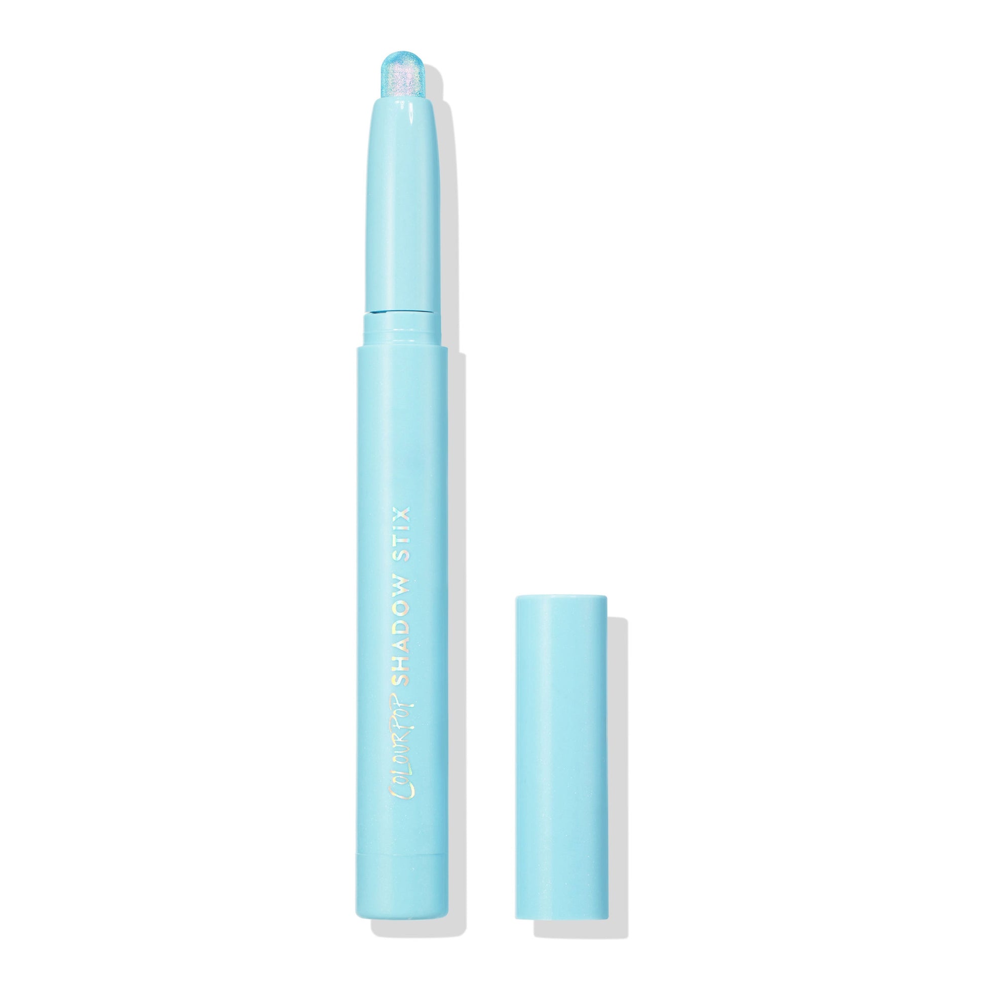 Colourpop Game Over Shadow Stix with shimmering icy blue cream eyeshadow bullet exposed, standing upright with cap off beside it on a clean white background for a minimalist product display.